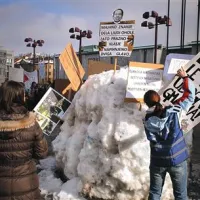 Del transparentov so protestniki v Ljubljani zapičili tudi v snežno skulpturo, ki upodablja glavo premiera Janeza Janše, in so jo neznanci prejšnji teden postavili pred Cankarjevim domom.