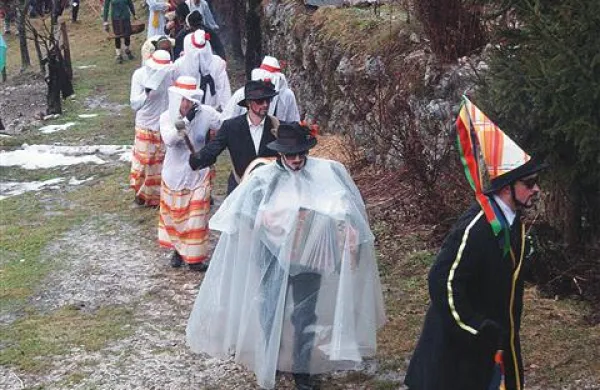 Muzikant je moral  v dežju masko dopolniti še z zaščito za  harmoniko