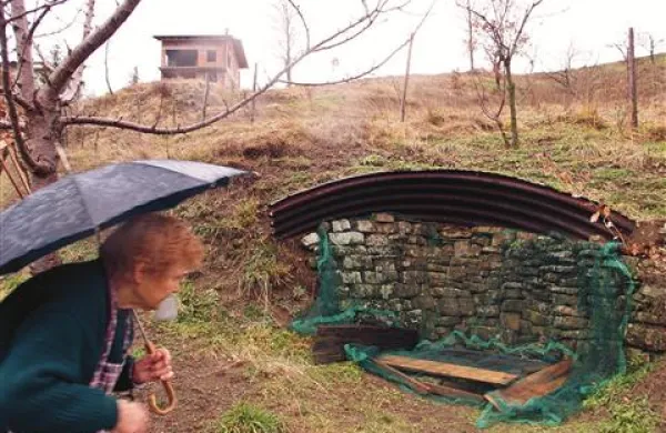 Marija Čečko ob zajetju vode, ki ga ogroža nastajajoči stanovanjski objekt (zgoraj)