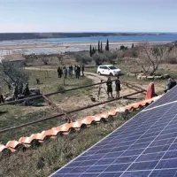   Čez kolektorje na strehi Maherjeve kleti se pogled odpira proti Sečoveljskim solinam 