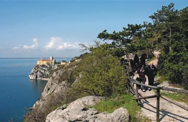 Slikovita pešpot nad pečinami pri devinskem gradu je priljubljeno sprehajališče tudi med številnimi Slovenci