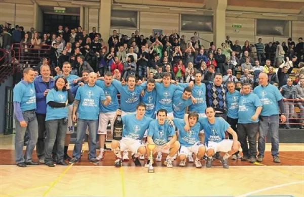 Prvaki tretje lige s pokalom, v ozadju pa njihov šesti igralec