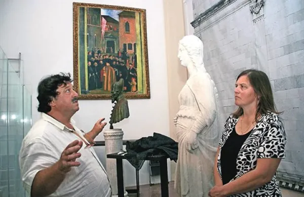 Kustos Edvilijo Gardina in restavratorka Lidija Gardina med pripravami  pred kipom Pravice, izvirnikom s Pretorske palače. V ozadju kip doža Nicoloja Donata, nad njim replika znamenite Carpacciove slike, ki so jo z ostalimi umetninami leta 1940