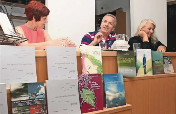 Spraševalka Jasna Čebron (levo), pesnik Enzo Santese in karikaturitska Lorella Fermo v knjigarni Libris