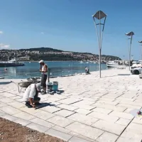 Včeraj so delavci polnili fuge na novo tlakovanih površin ...