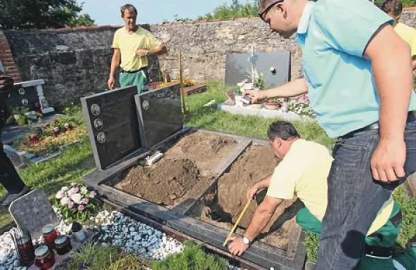 Preden je naročil premik betonskega okvirja in spominske plošče na grobu Bizjakovih, se je izvršitelj Tadej Poljak (desno) s pomočjo komunalnih delavcev prepričal, da so krste dovolj oddaljene od sosednjega groba