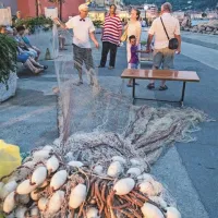 Potrpežljivo in natančno šivanje ribiških mrež ... 