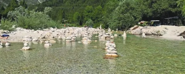 Mrzla Soča je bila v  vročih dneh letošnjega poletja še kako primerna za ohladitev, kot kaže, pa tudi za ustvarjanje z belimi rečnimi kamni