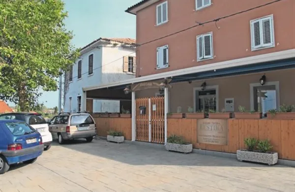 Dostop do zapuščenega vaškega doma (v ozadju) je možen le prek trgca pred gostinskim lokalom v središču Hrvatinov