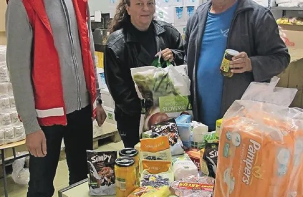 Poslovni sekretar koprskega RK Andrej Gustinčič, sodelavka v sociali Milena Bužan in prostovoljec Hasan Felič pred kupom plenic in prehrabmenih izdelkov, namenjenih otrokom, starim do sedem let