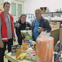 Poslovni sekretar koprskega RK Andrej Gustinčič, sodelavka v sociali Milena Bužan in prostovoljec Hasan Felič pred kupom plenic in prehrabmenih izdelkov, namenjenih otrokom, starim do sedem let