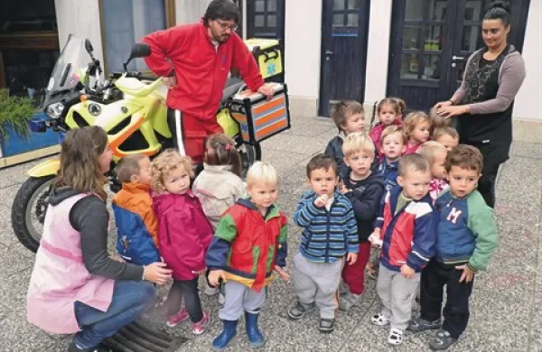 Reševalec Andrej med škofijskimi otroki. Najbolj jih je seveda zanimal njegov motor ...