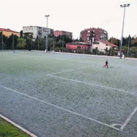 Eno od dveh pomožnih igrišč ob stadionu. Bolj kot umetno travo je videti  njeno  polnilo, kar botruje marsikateri poškodbi.