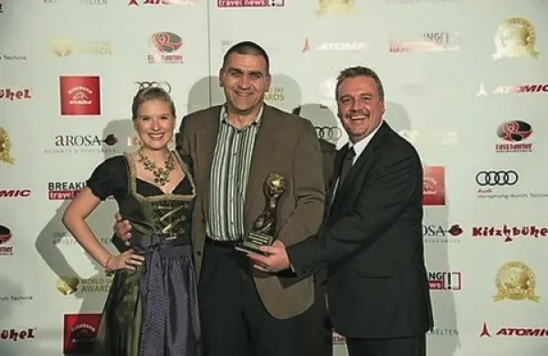 Županu Kranjske gore Juretu Žerjavu (v sredini) sta priznanje podelila mična tirolska hostesa in podpredsednik World Travel Awards Chris Frost