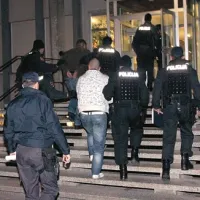 Štirje osumljenci so skozi vrata sodne palače v spremstvu do zob oboroženih policistov vstopili nekaj po 19. uri
