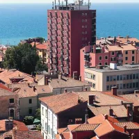 Rdeča stolpnica štrli iz mestne vedute, kar je posledica povojne arhitekture  Eda Mihevca