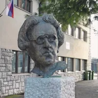 Tako prodorno in zvedavo se izpred Ljudske univerze v Sežani ozira Srečko Kosovel na levo v Kosovelovo ulico, ob kateri  stojijo Kosovelov dom, osnovna šola Srečka Kosovela in Šolski center Srečka Kosovela, pa na desno, kjer domuje Kosovelova knjižnica,