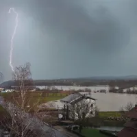 Pogled s stanovanjskega bloka v Rozmanovi na razlito reko Reko in hudournike, ki so ustvarili med  Žabovco in Dolnjim Zemonom (v ozadju) pravo jezero