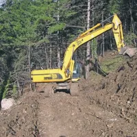 Včeraj se je bager prebil do mesta, kjer se bo začel graditi nasip. Levo spodaj je videti skalo, ki se je po zadnjem podoru ustavila le 30 metrov nad cesto.