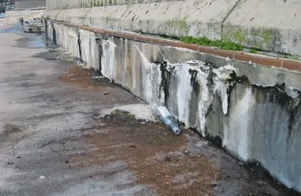 Vtis že tako  neuglednega zidu ob bazenu Metropola še “popravi” odvržena steklovina