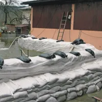 Če je prve dni poplav še zadoščala ena vrsta vreč peska, jih morajo zdaj zložiti po meter v višino in podpreti še z drugo vrsto, da vsaj za silo in za nekaj časa kljubujejo pritisku vode