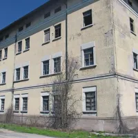 V nekdanjih trnovskih vojašnicah, kjer je obrtno industrijska cona, je edina prazna in razpadajoča velika stavba, v kateri je bil po letu 1992 begunski center
