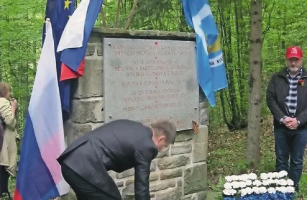 Predstavnik ruske ambasade v Sloveniji Roman Cigancev polaga cvetje pred spominsko ploščo bolnišnice Zalesje, desno je bistriški župan Emil Rojc