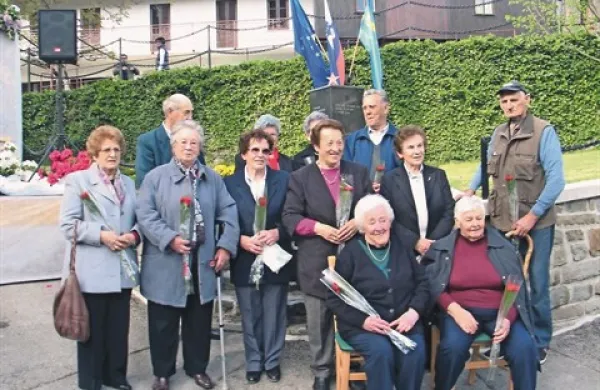 Dvanajst Sušačank in Sušačanov, ki so doživeli tragične dogodke leta 1944, pred spomenikom žrtvam vojne 