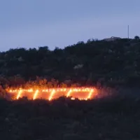 Napis nad Novo Gorico že desetletje vsako leto na predvečer dneva zmage osvetlijo z baklami 
