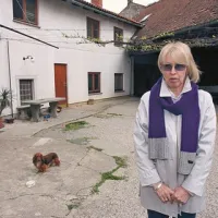 Anny Žerjal Cereali na dvorišču hiše v Dutovljah, kjer so živeli pred prisilnim odhodom članov njene družine v tujino
