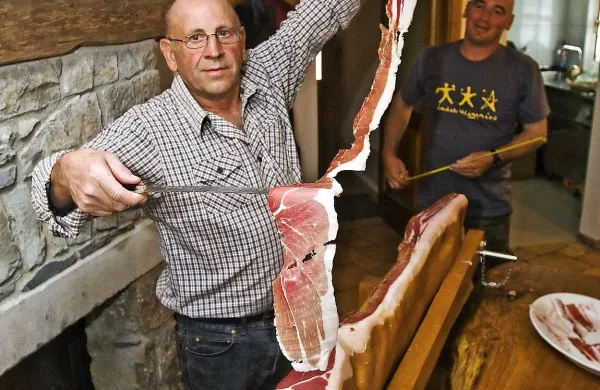 Rekordna rezina suhe mesnine Emila Tavčarja je merila kar 130 centimetrov. Asistira mu sin Ken. 