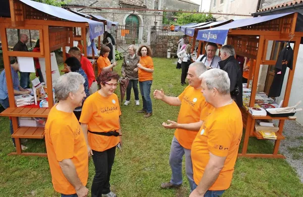 Organizatorji (v oranžnem) so  prvi sejem kuharskih knjig v Volčjem Gradu   izpeljali uspešno, čeprav so jih kritizirali, da ob knjigah kraške kulinarike namesto kraških jedi ponujajo čevapčiče in kalamare