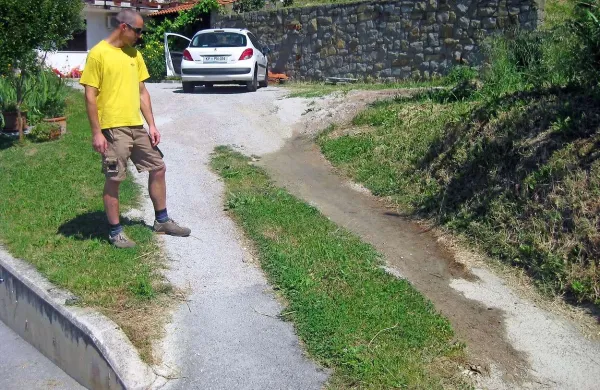 Umazana voda, ki se že več let nabira ob meteorni kanalizaciji na dvorišču družine Lovrič, teče tudi po dovozni poti in po cesti, ki pelje na Malijo 
