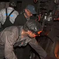 Na  tone premoga je moral kurjač z lopato zmetati v peč