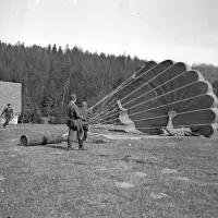 Vojsko na Idrijskem  aprila 1945: s padalom odvrženi cilinder z materialom, ki so ga partizanskemu gibanju na Slovenskem pošiljali zavezniki, pakirali pa pripadniki 4. prekomorske brigade