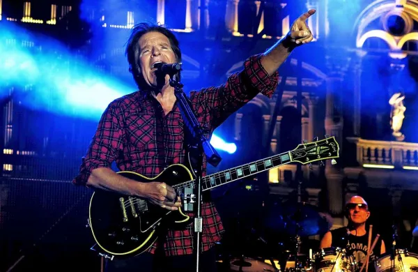 John Fogerty, motor pokojnega kultnega benda Creedence Clearwater Revival,  na osrednjem tržaškem trgu, s prstom, usmerjenim v bližajoče se neurje, ki je pretrgalo zabavo 