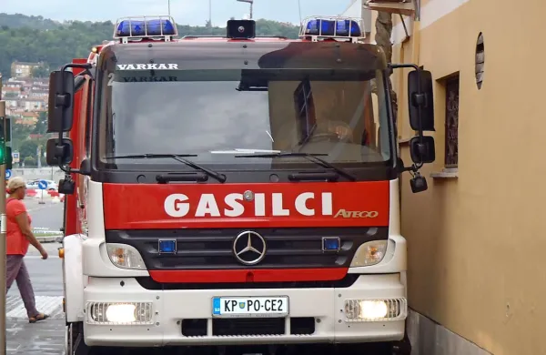 Voznik gasilskega tovornjaka je moral na nujni vožnji paziti, da ne poškoduje tovornjaka, hiše ali semaforja
