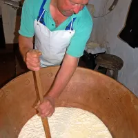 Miran Prezelj s trnačem drobi sirna zrna v starem kotlu 