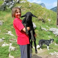 Tanja z jagnjetom, ki bo še dajalo mleko, zadaj pastirska psička Kala