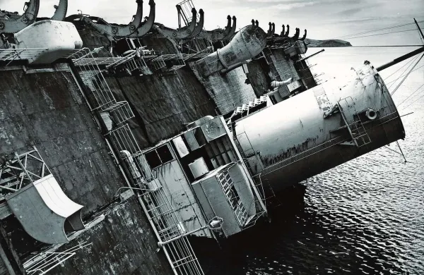 “Ko se je Rex prevrnil na bok, je jokalo železo kot prestrašen otrok ...” v Junaku prekomorskih brigad poje Drago Mislej Mef. Fotografija pa je iz leta 1946 iz knjige Maurizia Elisea Il transatlantico Rex, ship of ships.
