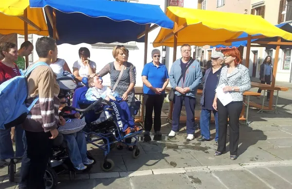 Angela Lampe (v sredini), mati invalidnega otroka s cerebralno paralizo, je skupaj z drugimi starši in podporniki predstavila peticijo za vrnitev denarja za gradnjo  zavoda na Debelem rtiču