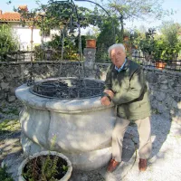 Stanko  Boljev ob dvesto let starem vodnjaku pred svojo rojstno hišo  
