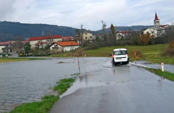 Lokalno cesto med Knežakom in Koritnicami je voda zalila na več odsekih
