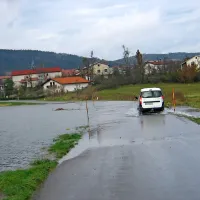 Lokalno cesto med Knežakom in Koritnicami je voda zalila na več odsekih