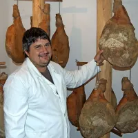 Marko Tušar med blago dimljenimi pršuti, za katere je zadolžen na domačiji Pri Flandru