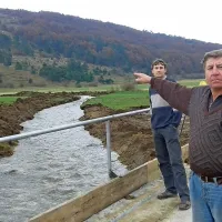 Domačin Miro Tomažinčič kaže proti Tuščaku, pod katerim izvirajo vode, ki so zalile Koritnice in Bač; k sreči so jih s prekopom “ujeli” v pravcato reko, za katero mnogi menijo, da še dolgo ne bo presahnila 