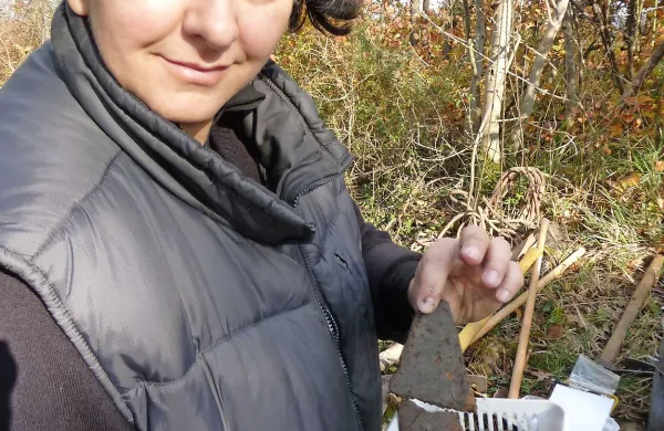 Alenka Tomaž kaže koščke žgane gline 
