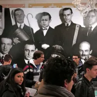 Italijanski šolarji v sobi, kjer je razobešen tudi skupinski portret dadaistov.  