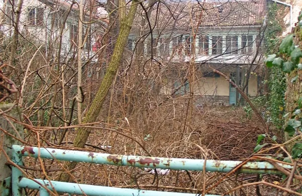 Pogled čez vrtno ograjo kaže, da tu že dolgo ni bilo nikogar. 