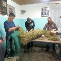 Mlajši del fantovske skupnosti pri šivanju maha na Pustovo oblačilo.